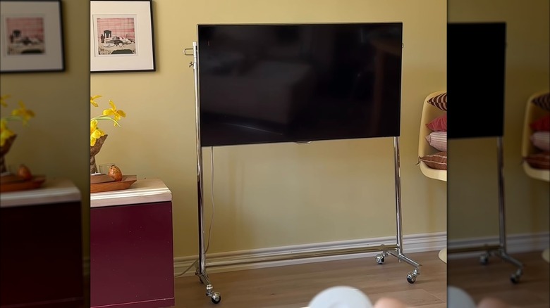 TV mounted on a clothing rack in a small living room