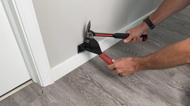 Using a trim puller to remove baseboards.