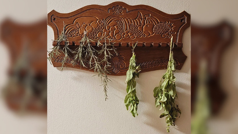 Antique spoon holder used as herb drying rack