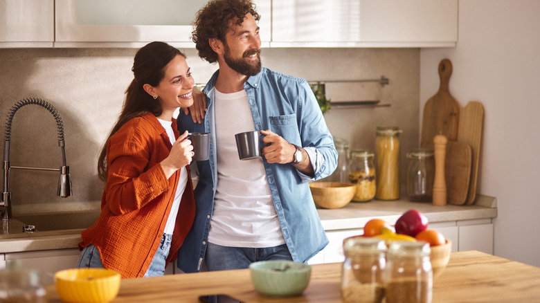 Couple in kitchen drinking coffee next to bar-height counter