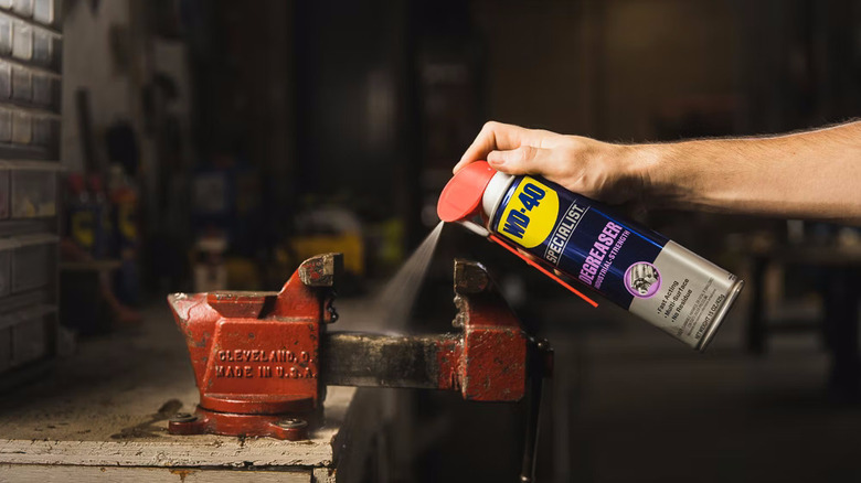 someone spraying WD-40 Specialist Degreaser on a metal bench vise