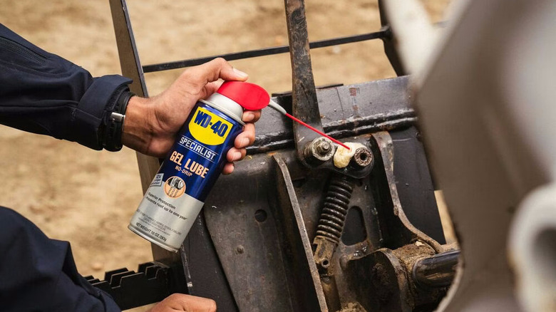a person applying WD-40 Specialist Gel Lube on a machine