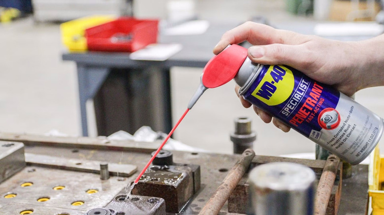 a person spraying the WD-40 Specialist Penetrant on a bolt holder