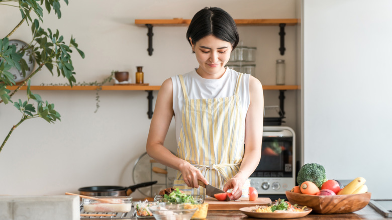 A young Asian woman cooking in the kitchen