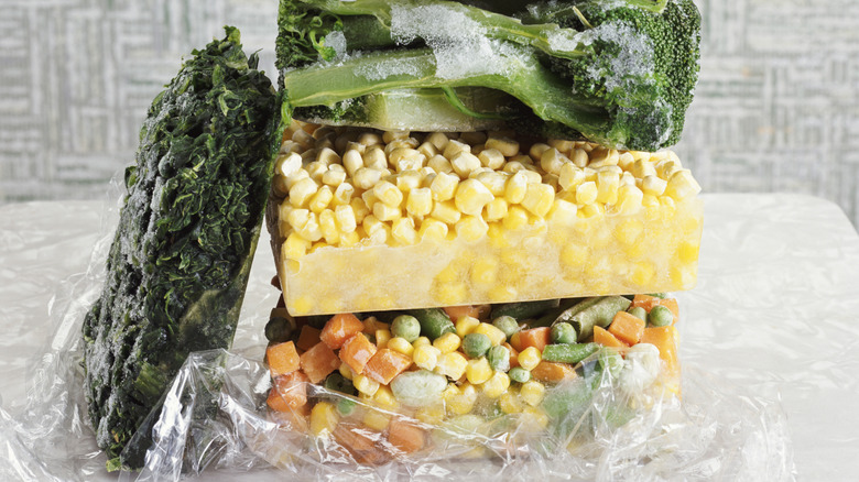 Blocks of freezer-burned vegetables covered with ice crystals