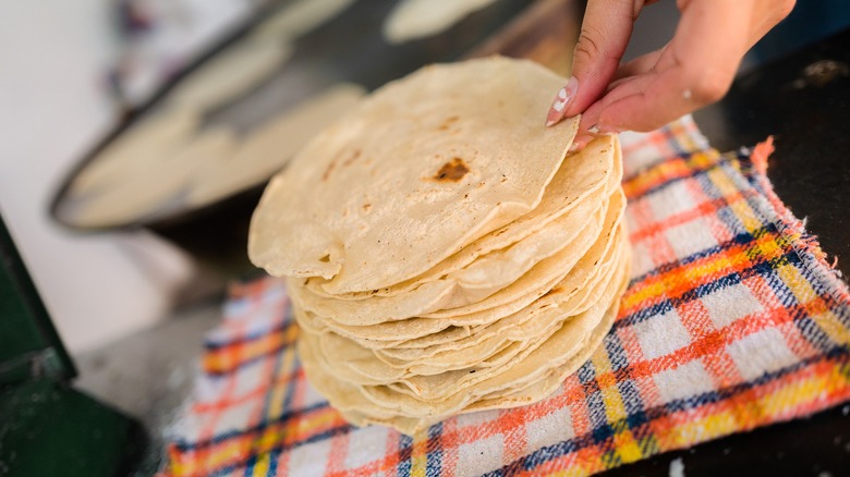 Tortillas being stacked on a mat