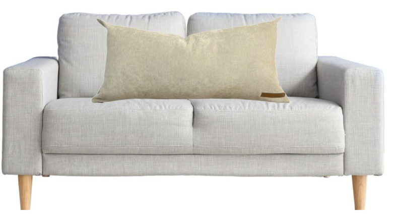 The Storage Pillow XL on a sofa