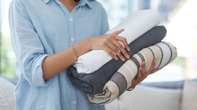 Woman holding a pile of folded towels