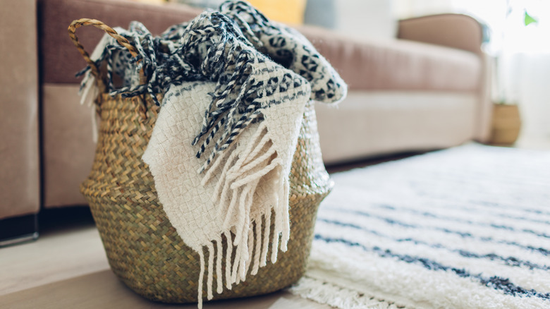 a wicker basket overflowing with blankets