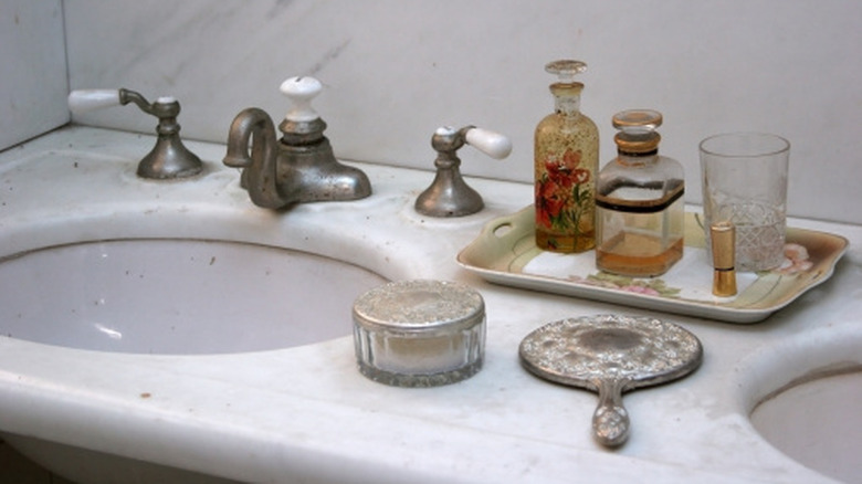 A bathroom counter with an array of vintage objects