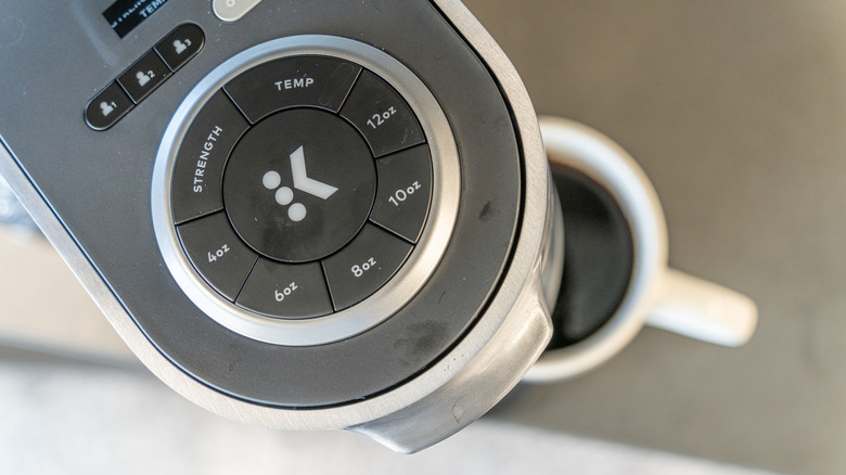 The top of a Keurig coffee machine with a mug of coffee underneath