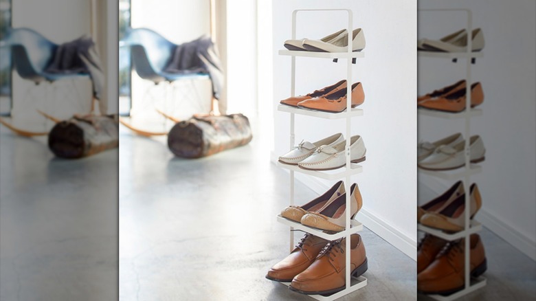 Yamazaki Home shoe storage rack in a brightly lit room with five pairs of shoes stacked vertically