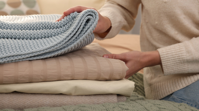 Woman putting blankets in a pile
