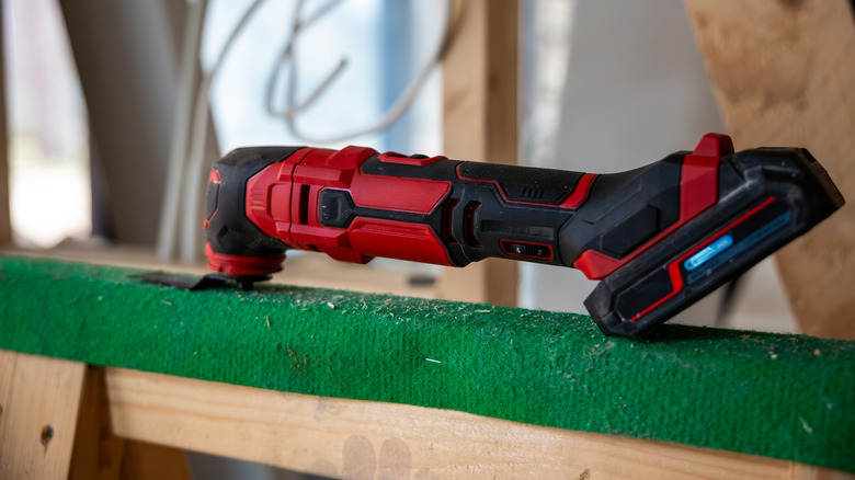 An oscillating multi-tool sitting on a sawhorse