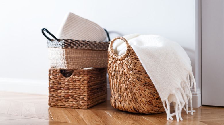 Several baskets on the ground filled with blankets