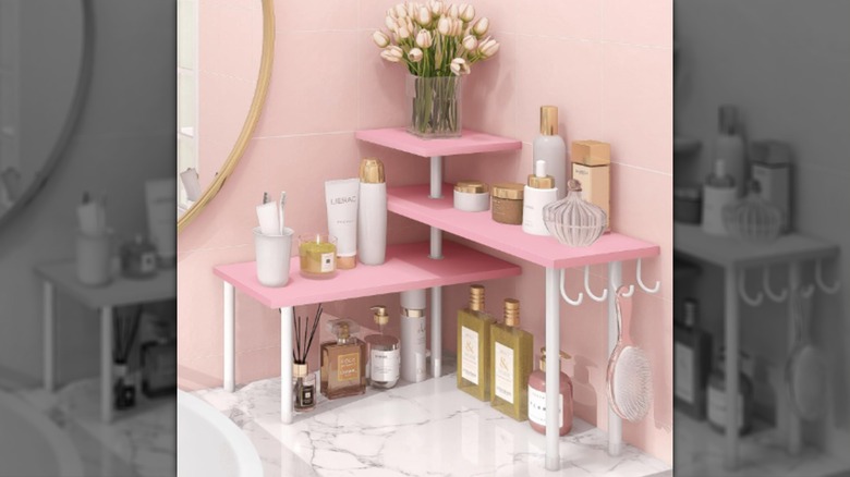 A three-tiered pink shelf with storage hooks from Homode