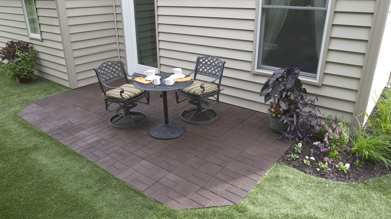 A rubber paver patio made with Rubberific tiles outside the back of a house.