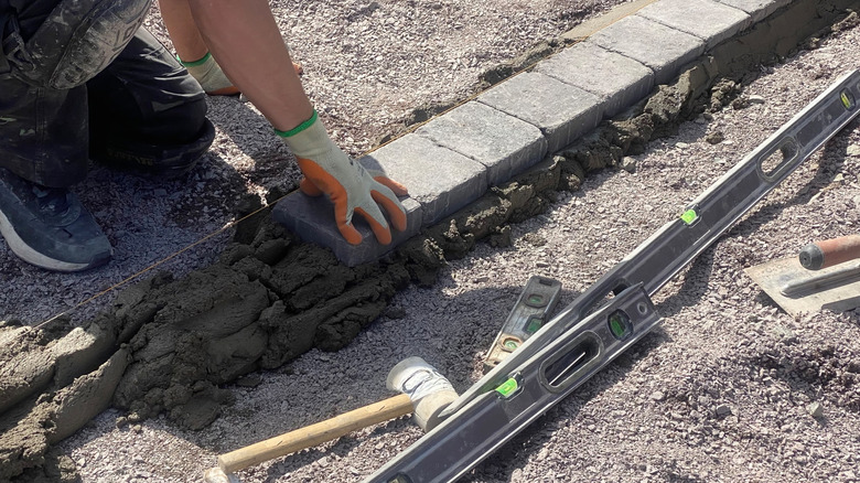 A person installing edging pavers