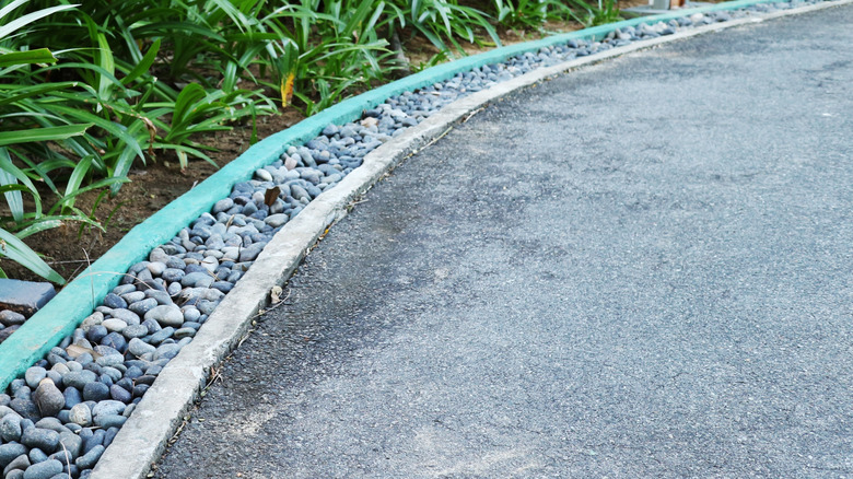A driveway border mixing gravel and rocks for visual interest