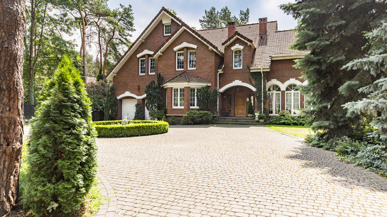 A house with an elegant driveway leading up to it with paver edging on the side