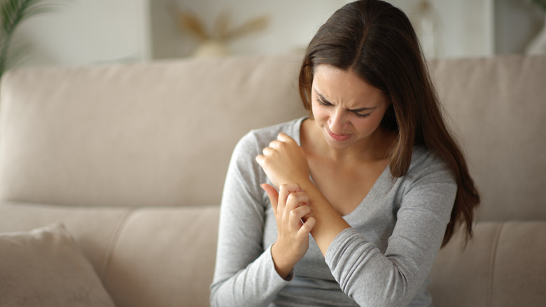 Closeup of a woman scratching her arm that has a mosquito bite