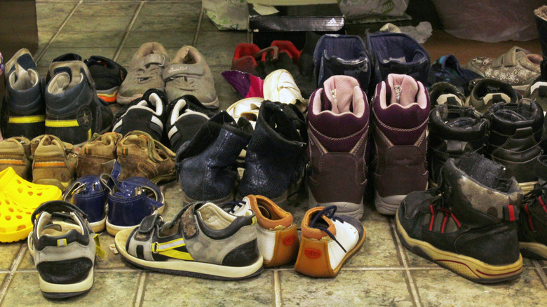 A messy assortment of shoes laid messily on the ground