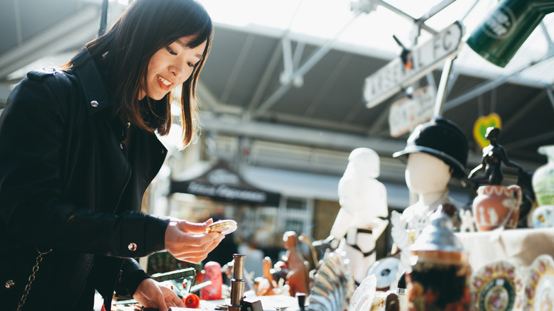 woman examining different antique items