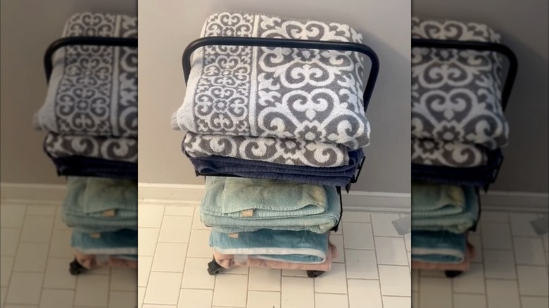 bathroom towels stacked on a rolling cart