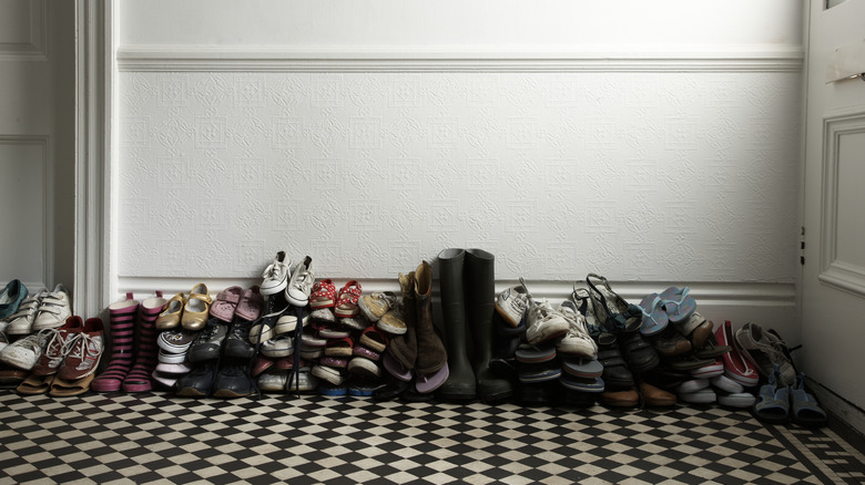 A row of various shoes on the floor.