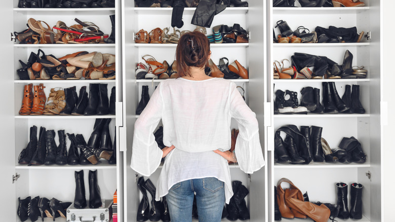 A woman standing in front of a shoe cabinet.
