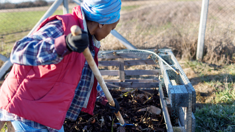 Woman mixing a compost pile