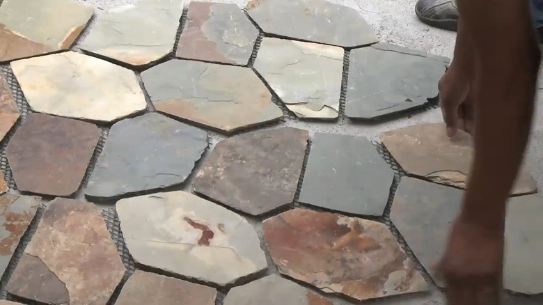Person installing meshed flagstone