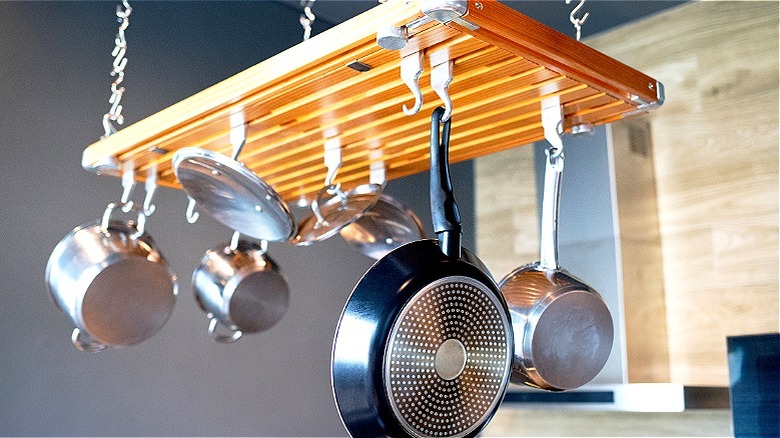 Wooden cookware rack holding stainless steel cookware
