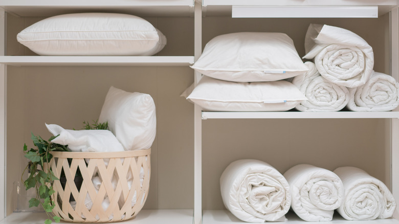 View of shelves in a house filled with pillows and bed linens