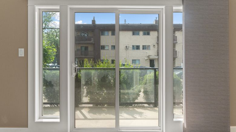 White sliding glass doors let the heat into an empty dining room.