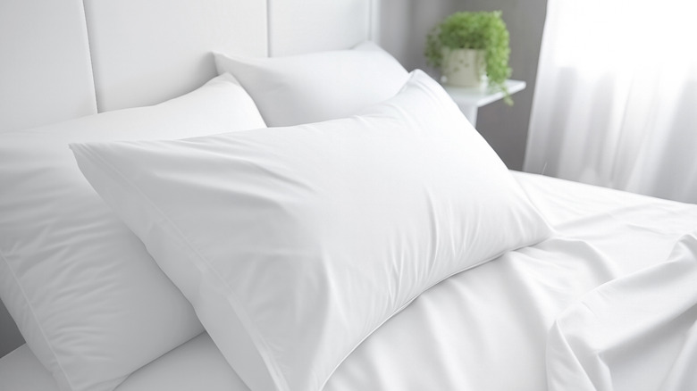 Closeup of white sheets and pillow covers on a bed