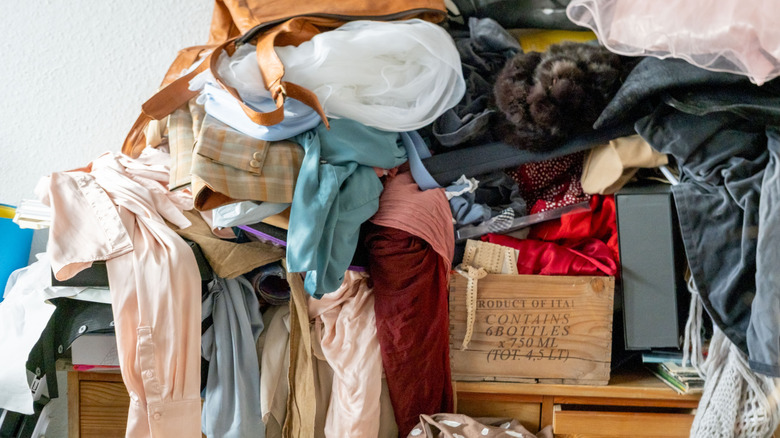 Desk covered with clothes and other items