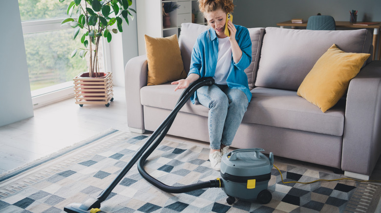 Woman trying to fix a broken vacuum