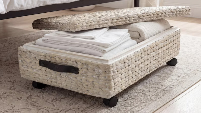 Under-the-bed bin of folded sheets and towels