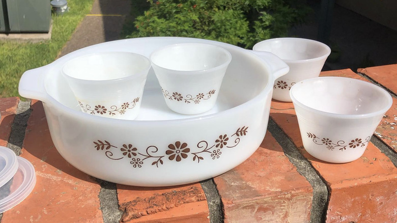 Four small and one large Dynaware bowls sitting on a brick wall outdoors.