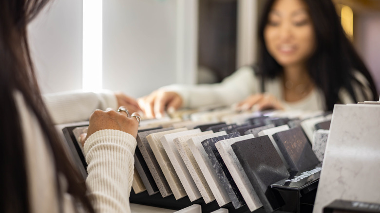 A woman looking through samples of materials for countertops