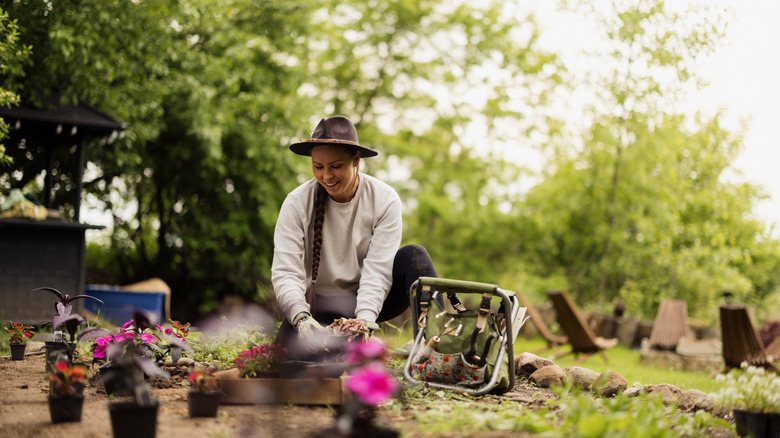 person planting various flowers outside