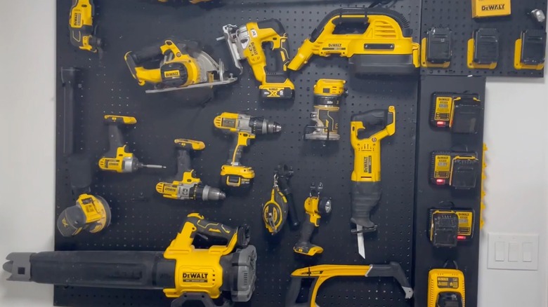 Power tools hanging on a metal pegboard