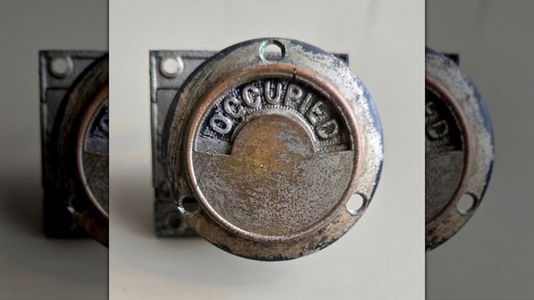 Antique bathroom door privacy indicator locking latch that says occupied.