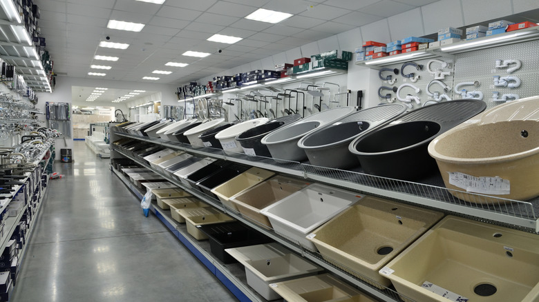 Kitchen sinks made from various materials for sale in a hardware store.