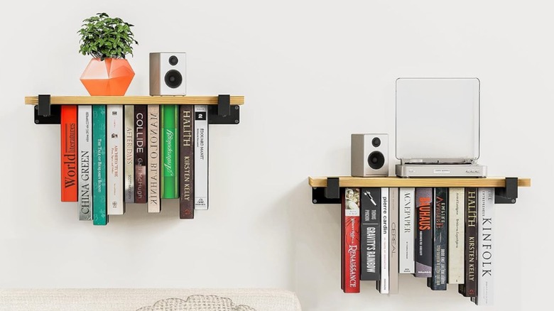 two floating selves with floating books under the shelf and speakers and a plant on top