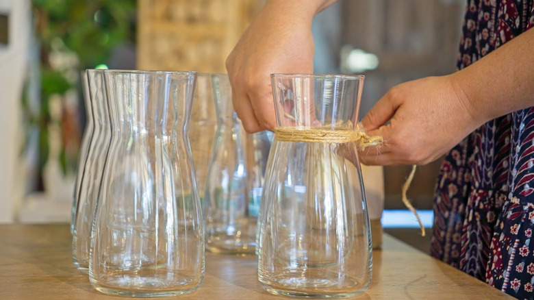 Person working with clear vase glasses for DIY project