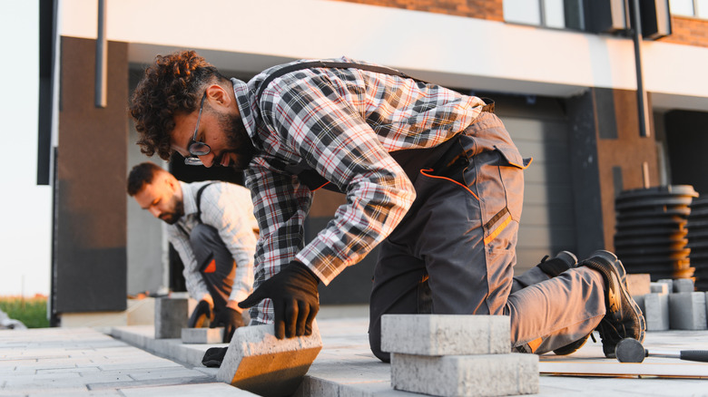 Workers installing driveway pavers