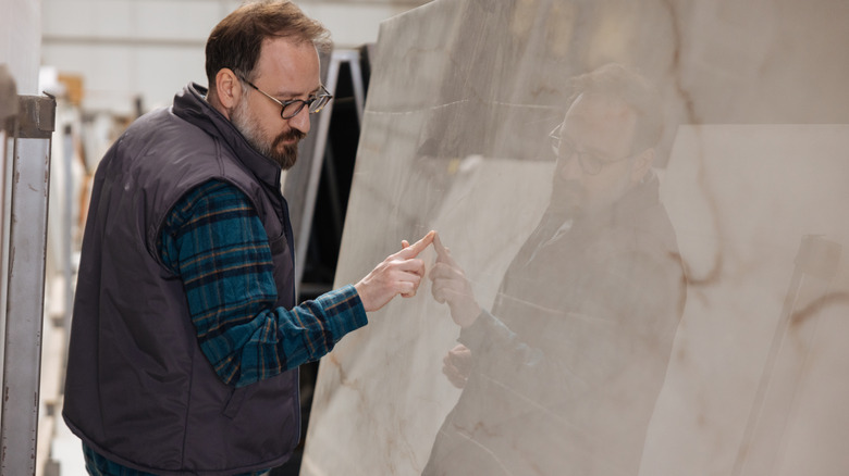 Man looking at a large piece of quartz countertop