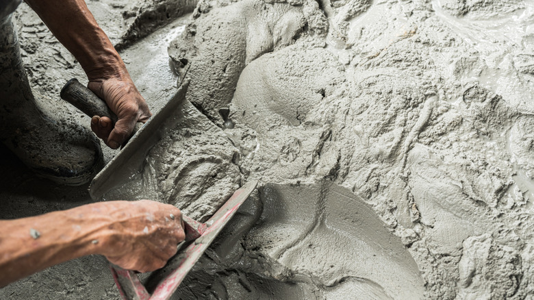 Man scooping cement from the floor